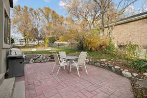 Fenced backyard featuring outdoor dining area, a patio, and a grill