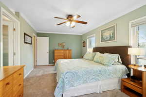 Bedroom featuring crown molding, carpet floors, and ceiling fan