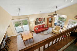 Living area with vaulted ceiling, a chandelier, and a ceiling fan