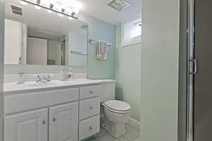 Full bath featuring vanity, light tile patterned flooring, and a shower with door