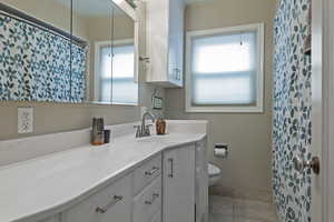 Full bathroom featuring a shower with shower curtain, vanity, and light tile patterned floors