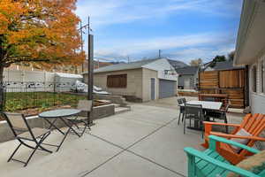 View of patio with an outbuilding, outdoor dining space, and a garage