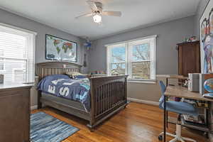 Bedroom featuring light wood-style floors, a ceiling fan, and an office area