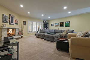 Living room featuring ornamental molding, light colored carpet, recessed lighting, and a high end fireplace