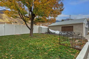 Fenced backyard with a gate and an outbuilding