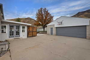 View of patio / terrace featuring a mountain view, an outbuilding, french doors, and a detached garage