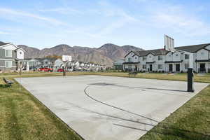 View of basketball court featuring community basketball court, a yard, and a residential view
