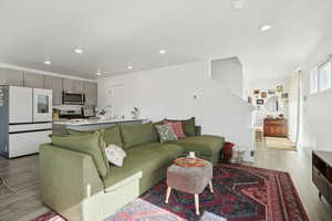Living room with light wood finished floors and recessed lighting