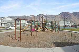 Communal playground featuring a mountain view and a residential view