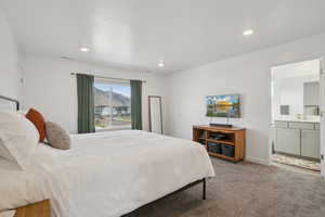 Bedroom with carpet floors, ensuite bathroom, and recessed lighting