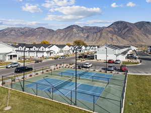View of tennis court with a mountain view and a residential view