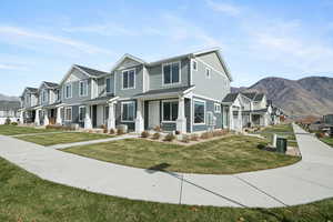 View of front of property featuring a residential view, a mountain view, and a front yard
