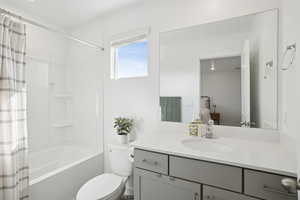 Ensuite bathroom featuring shower / tub combo with curtain and vanity