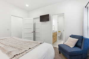 Bedroom featuring light tile patterned flooring, connected bathroom, recessed lighting, and a closet