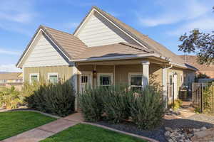 Bungalow featuring a tile roof, board and batten siding, and covered porch