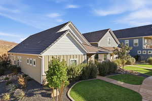 View of front of property with board and batten siding and a front lawn