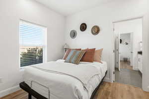 Bedroom featuring wood finished floors and baseboards