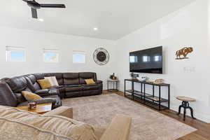 Living area with wood finished floors, healthy amount of natural light, recessed lighting, and a ceiling fan