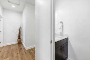 Half bathroom with vanity, light wood-style floors, and recessed lighting