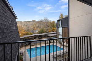 Community pool with a balcony, a patio, and a mountain view