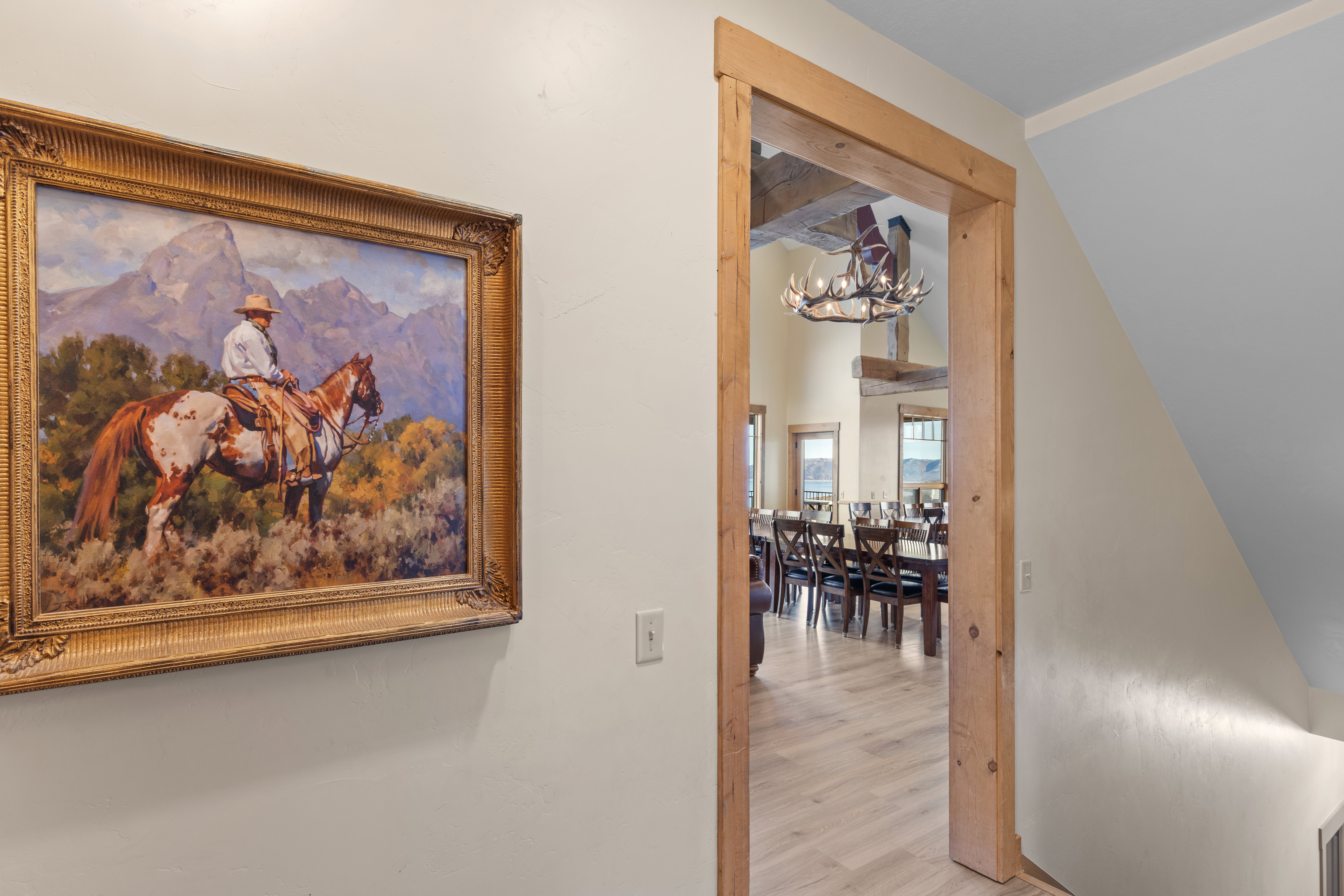 Hall with a chandelier, wood finished floors, and beam ceiling