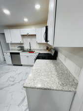 Kitchen with light marble finish flooring, range with gas stovetop, white cabinets, dishwasher, and recessed lighting