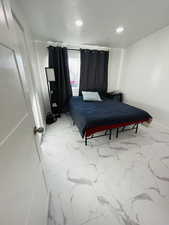 Bedroom with light marble finish flooring and recessed lighting