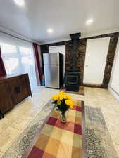 Living room with a wood stove, ornamental molding, and recessed lighting