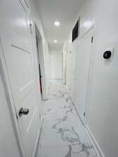 Corridor with light marble finish flooring and recessed lighting