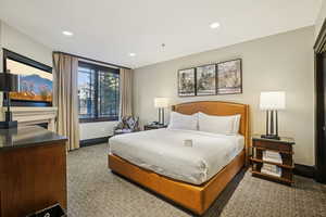 Bedroom featuring recessed lighting, carpet, and a fireplace