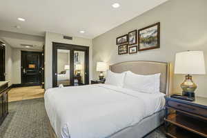 Bedroom with recessed lighting, a closet, light carpet, and light tile patterned floors