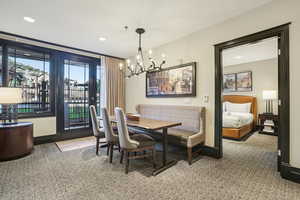Dining area with light colored carpet, recessed lighting, a chandelier, and light tile patterned floors