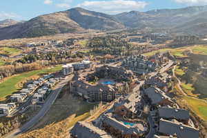 Aerial overview of property's location with a golf club and a mountain backdrop