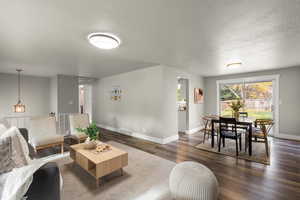 Living area featuring a textured ceiling and vinyl floors