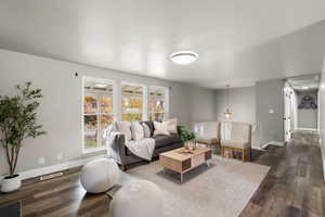 Living room featuring a textured ceiling and dark wood-type flooring