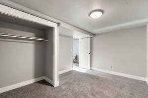 Unfurnished bedroom featuring a textured ceiling and carpet