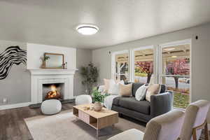 Living room featuring a textured ceiling, vinyl floors, and a brick fireplace