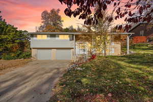 Home featuring a front lawn, brick siding, driveway, and an attached garage