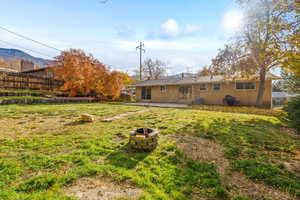 Back of property featuring a patio area, brick siding, an outdoor fire pit, and a chimney