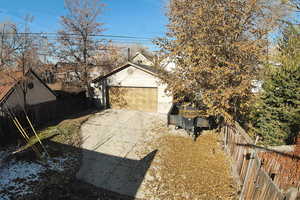 View of home's exterior with a garage, concrete driveway, and an outbuilding