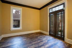 Entryway featuring crown molding, dark wood-type flooring, and french doors