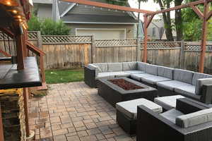 Fenced backyard with an outdoor living space with a fire pit and a patio