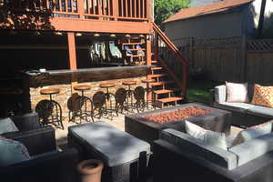 View of patio/terrace with an outdoor living space with a fire pit, stairway, a deck, and exterior bar