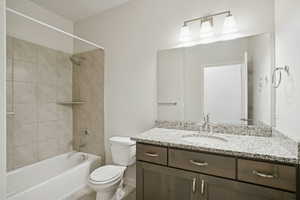Bathroom featuring  shower combination, vanity, and light tile patterned floors