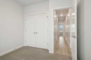 Corridor with carpet flooring and baseboards
