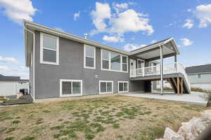Back of property featuring stairs, a patio area, a yard, and stucco siding