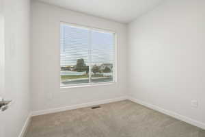 Spare room featuring light carpet and baseboards