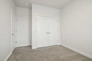 Unfurnished bedroom featuring carpet and a closet
