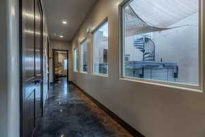 Hallway featuring concrete flooring and recessed lighting