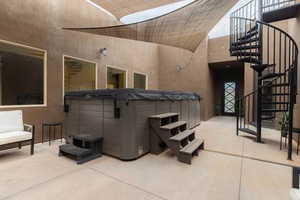 View of patio / terrace featuring stairway and a hot tub